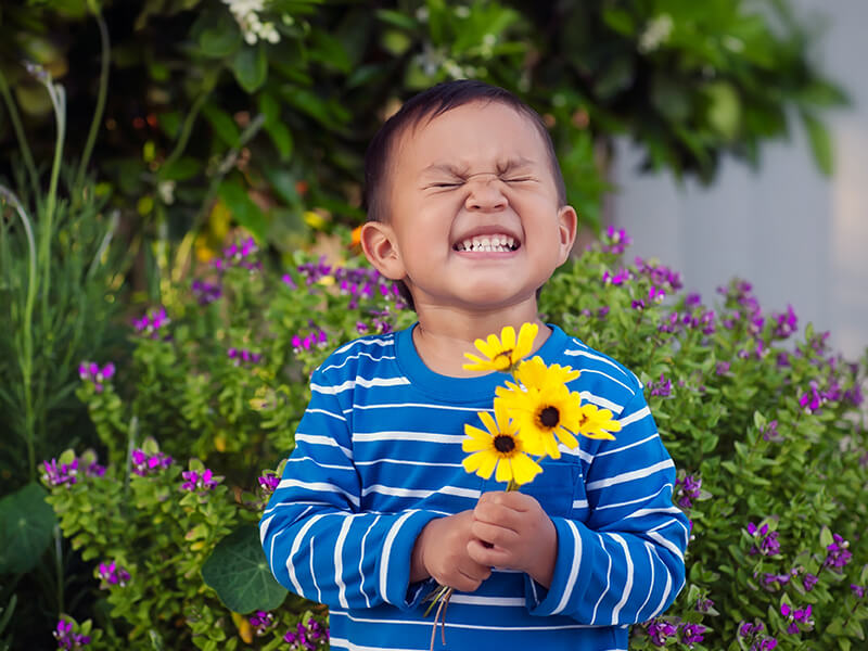niño sonriendo con flores