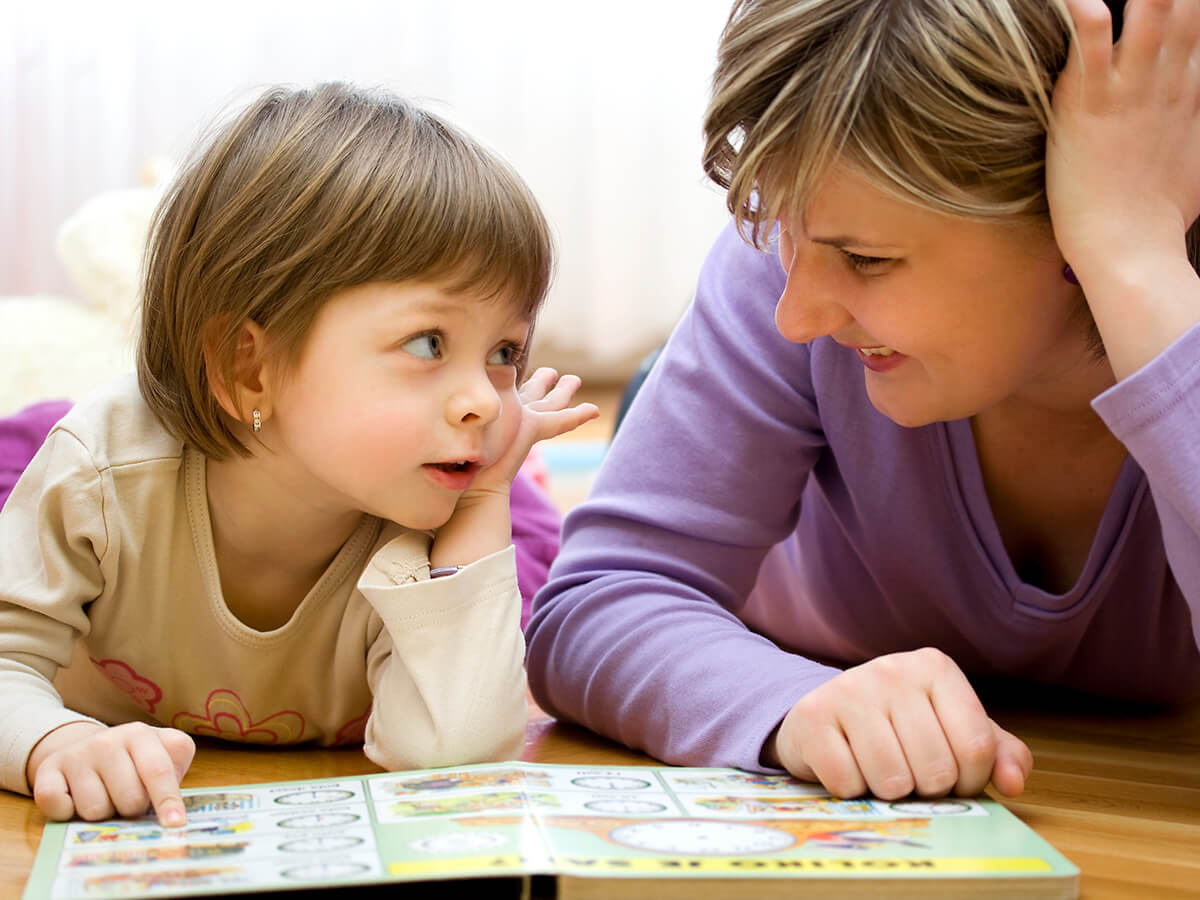 una niña y un cuidador leyendo