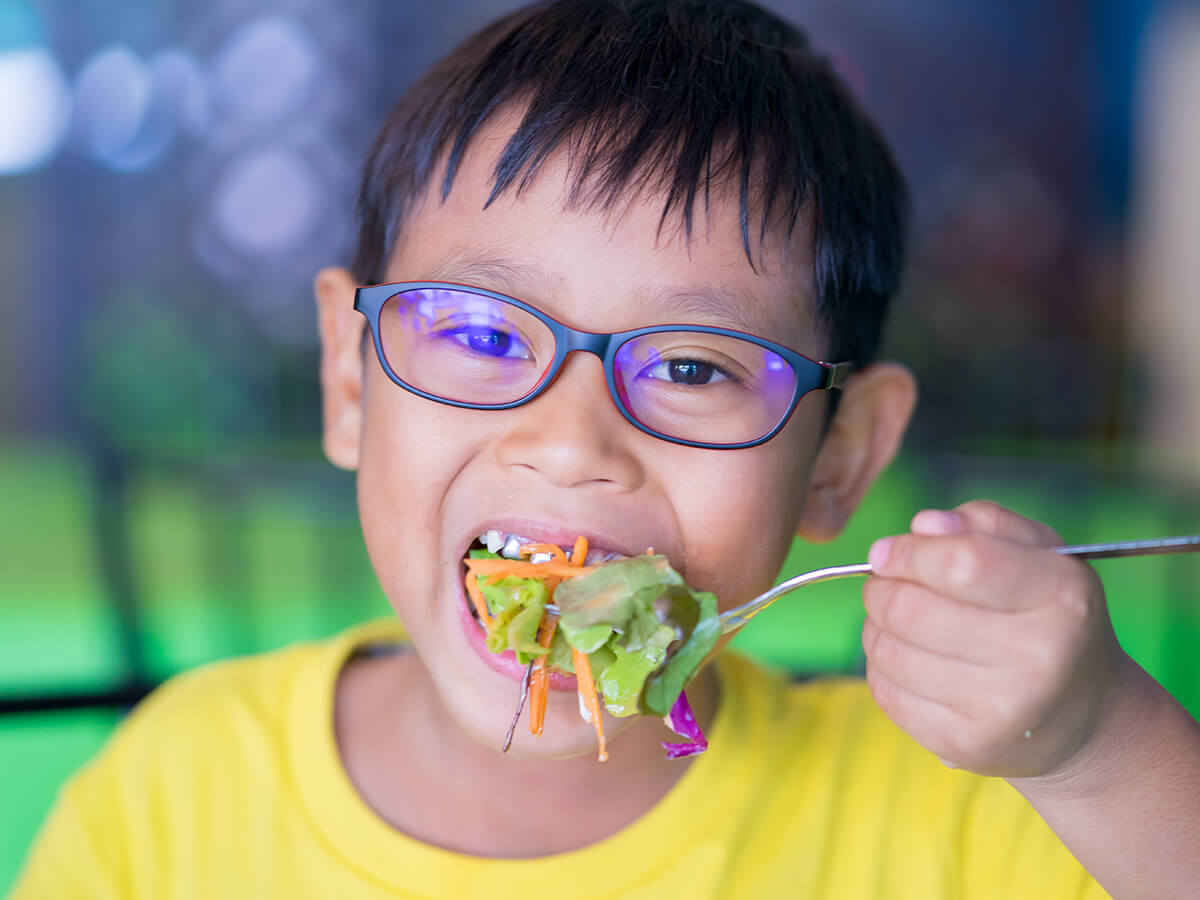 un niño comiendo una ensalada