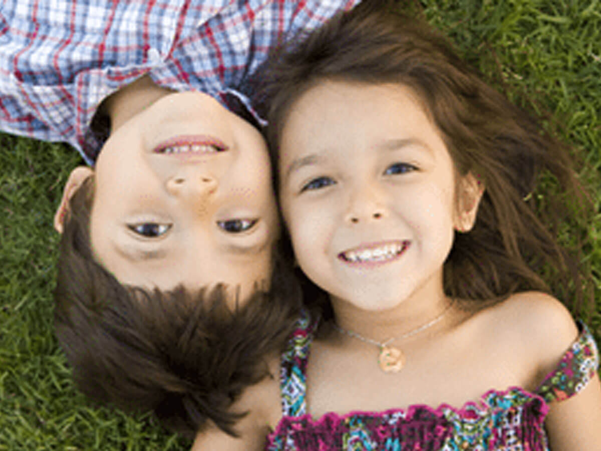 Hermanos en pasto sonriendo